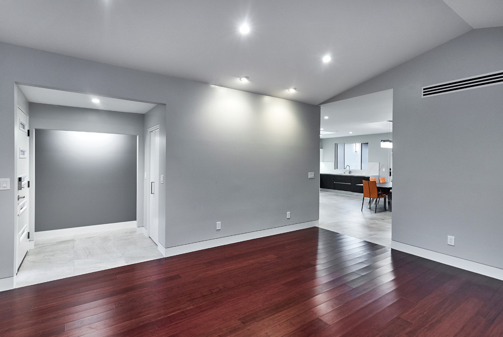 This is an example of a large contemporary formal enclosed living room in San Francisco with grey walls, dark hardwood floors, no fireplace and red floor.