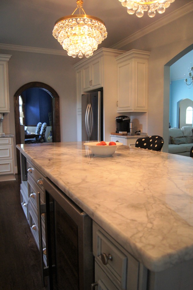 Inspiration for a large transitional single-wall dark wood floor and brown floor kitchen remodel with a farmhouse sink, marble countertops, white backsplash, stainless steel appliances and an island