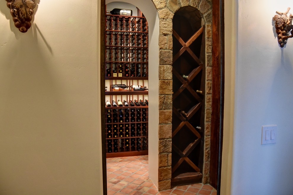 This is an example of a mid-sized asian wine cellar in San Diego with terra-cotta floors, display racks and orange floor.