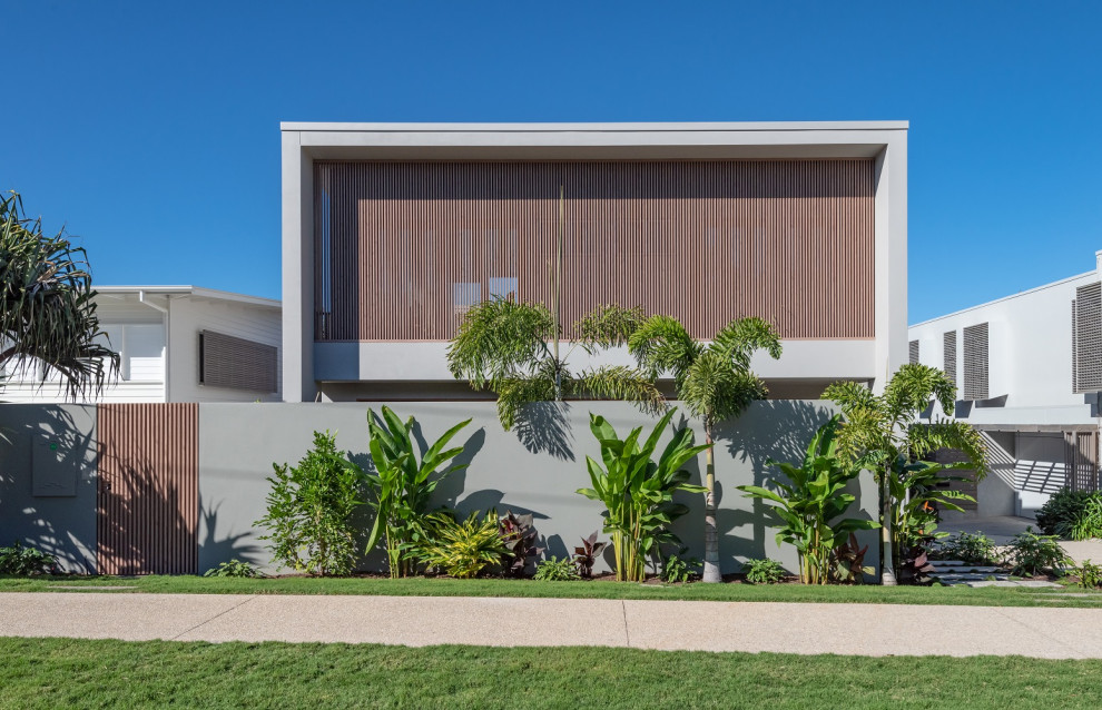 Inspiration for an expansive beach style two-storey white house exterior in Sunshine Coast with a flat roof.