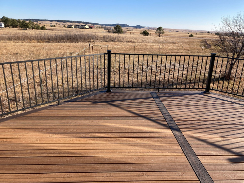 Inspiration for a mid-sized rustic ground level metal railing deck remodel in Denver