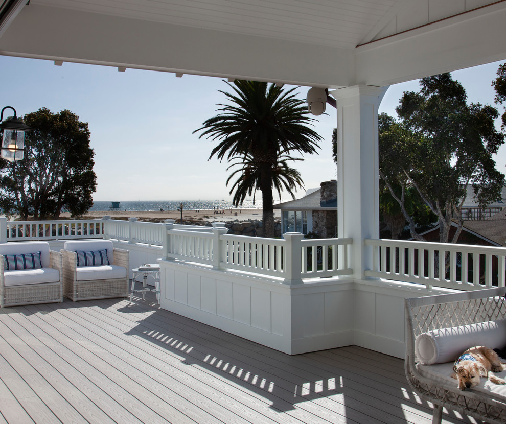 Photo of a large beach style side yard deck in San Diego with a fire feature and a roof extension.