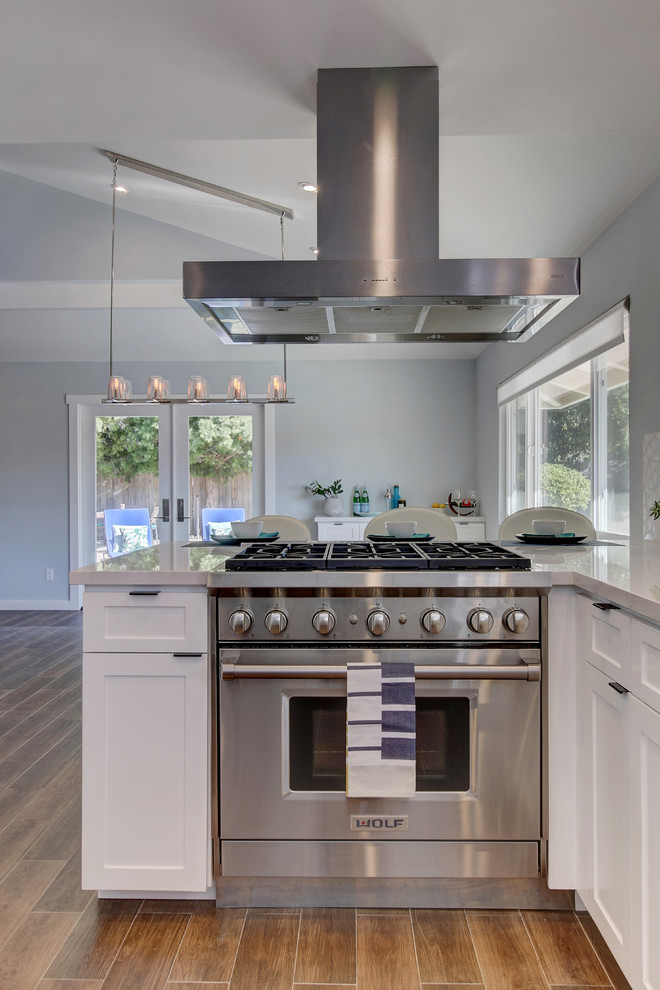 Mid-sized transitional u-shaped eat-in kitchen in Santa Barbara with an undermount sink, shaker cabinets, white cabinets, quartz benchtops, yellow splashback, mosaic tile splashback, stainless steel appliances, ceramic floors and a peninsula.