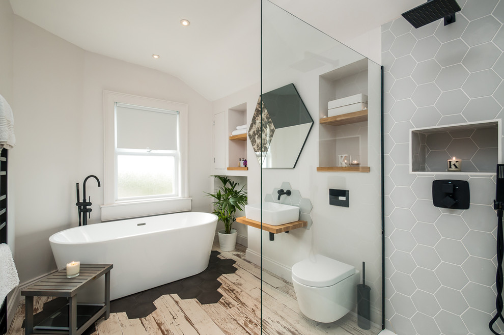 Inspiration for a modern 3/4 bathroom in Other with open cabinets, a freestanding tub, a wall-mount toilet, gray tile, white walls, a vessel sink, wood benchtops, multi-coloured floor, an open shower and brown benchtops.