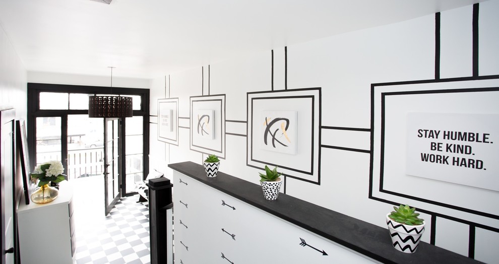 Example of a mid-sized transitional vinyl floor and black floor entry hall design with white walls and a black front door