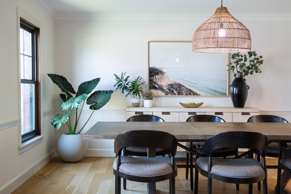 Inspiration pour une salle à manger ouverte sur la cuisine minimaliste de taille moyenne avec un mur blanc et parquet clair.