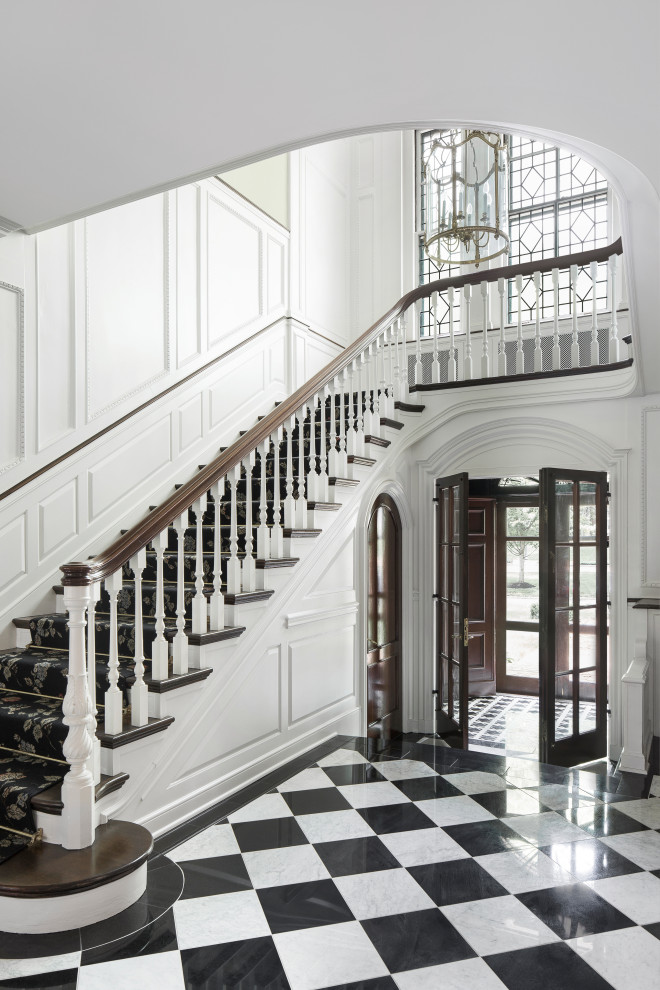 This is an example of a traditional foyer in St Louis with white walls, marble floors, a double front door, a dark wood front door and multi-coloured floor.