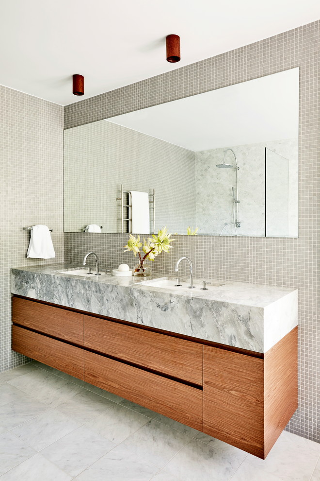 Design ideas for a large contemporary master bathroom in Sydney with medium wood cabinets, gray tile, glass tile, marble floors, an undermount sink, marble benchtops, grey floor and grey walls.
