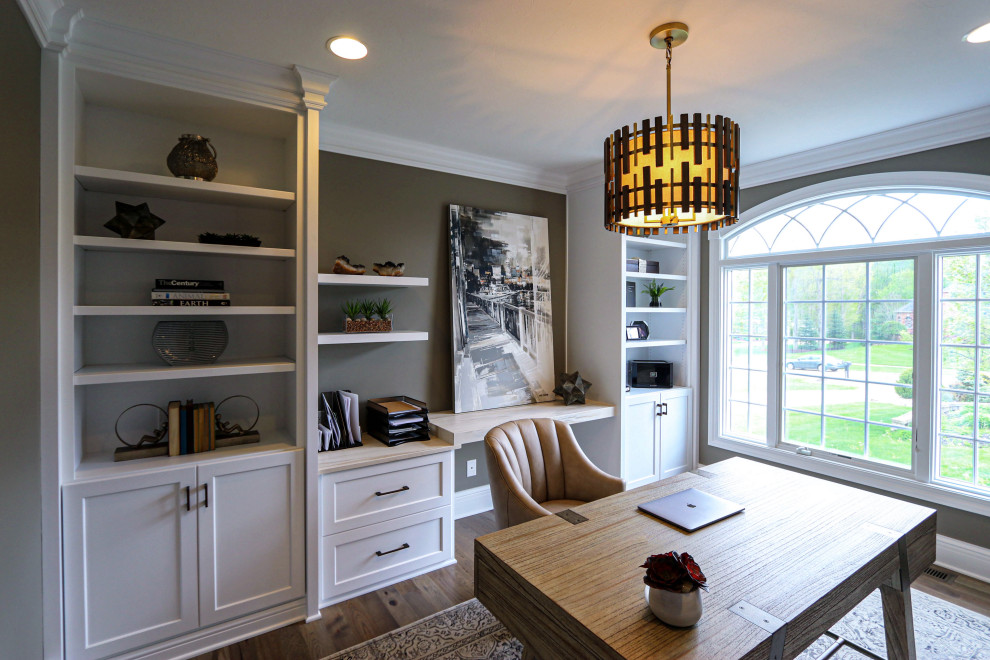 Ejemplo de despacho tradicional renovado de tamaño medio con paredes beige, suelo de madera en tonos medios, escritorio independiente y suelo marrón