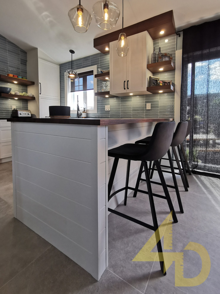 Ceramic tile, gray floor and vaulted ceiling eat-in kitchen photo with an undermount sink, shaker cabinets, white cabinets, solid surface countertops, blue backsplash, subway tile backsplash, a peninsula and black countertops