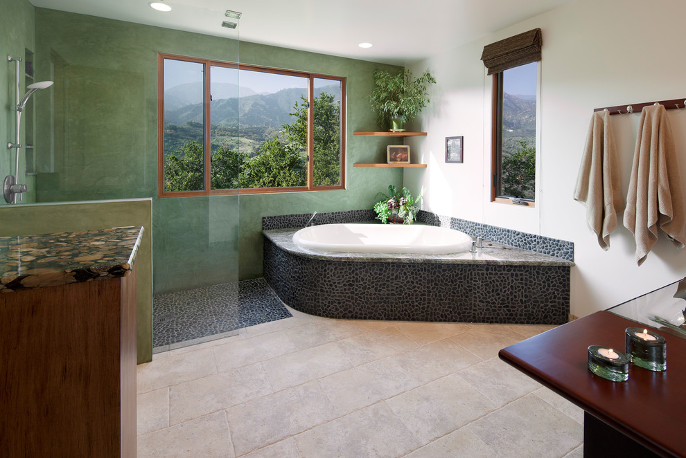 Large asian master bathroom in Santa Barbara with medium wood cabinets, a drop-in tub, a corner shower, gray tile, pebble tile, green walls, travertine floors, beige floor and an open shower.