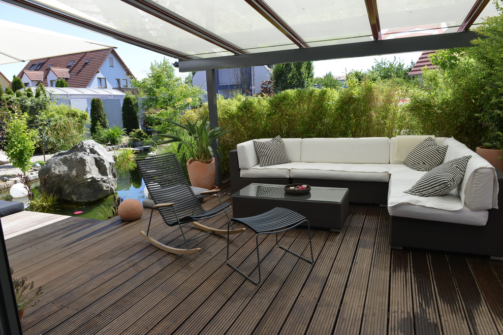 This is an example of a large contemporary backyard patio in Nuremberg with an awning and decking.