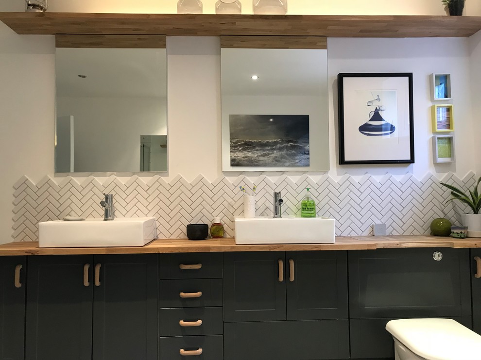 This is an example of a large contemporary kids bathroom in Sussex with shaker cabinets, turquoise cabinets, a drop-in tub, an open shower, a one-piece toilet, white tile, ceramic tile, white walls, vinyl floors, a trough sink, laminate benchtops, grey floor and a sliding shower screen.