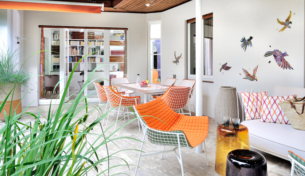 Großer Mid-Century Patio hinter dem Haus mit Markisen, Kübelpflanzen und Betonboden in München