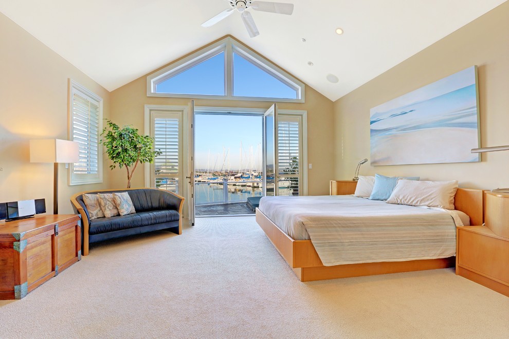 This is an example of a large beach style master bedroom in San Francisco with beige walls and carpet.