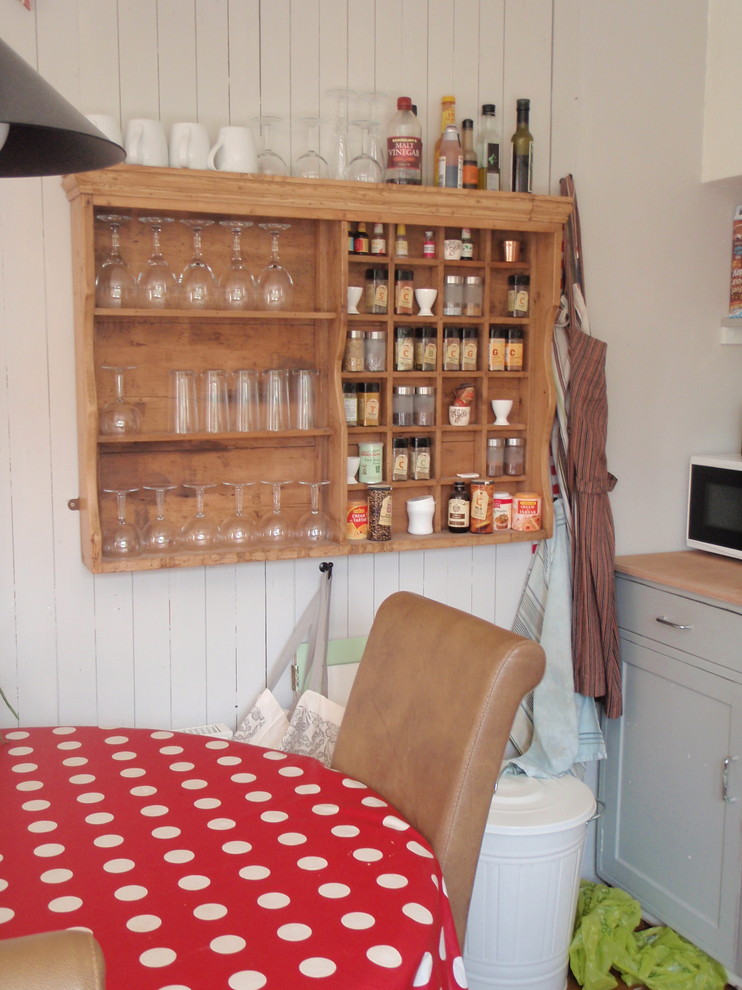 Mid-sized midcentury single-wall open plan kitchen in Hampshire with a farmhouse sink, shaker cabinets, grey cabinets, beige splashback, ceramic splashback, coloured appliances, medium hardwood floors, no island and wood benchtops.