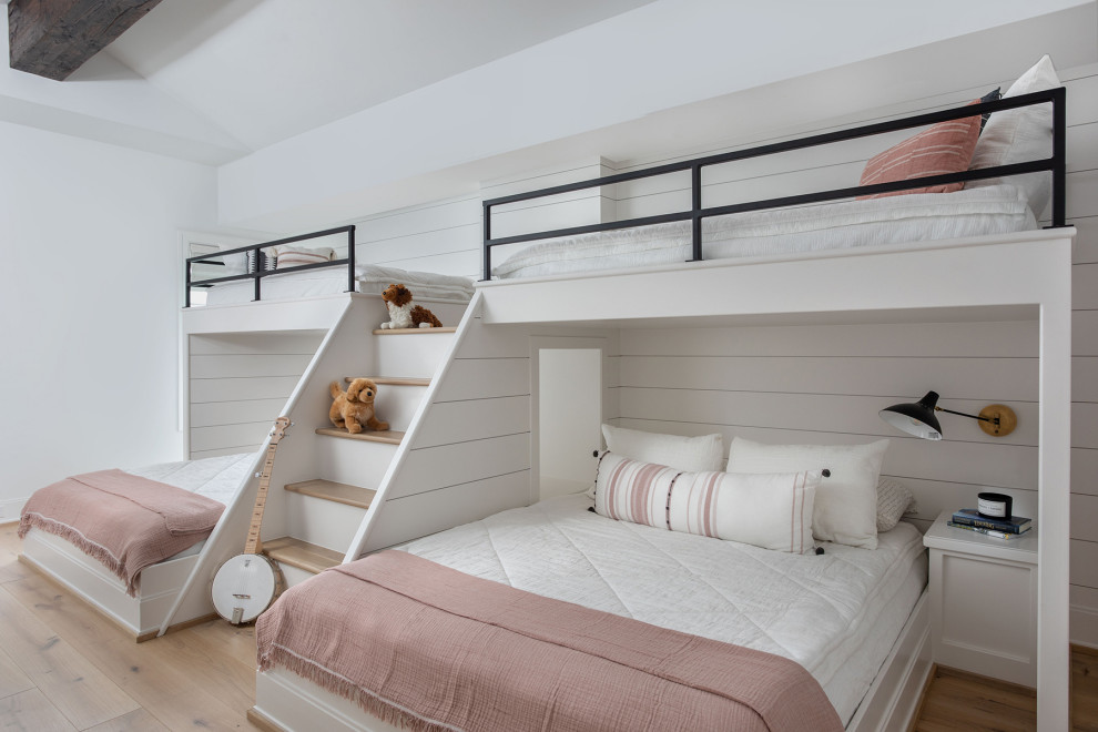 Photo of an expansive contemporary gender-neutral kids' bedroom in Houston with white walls, light hardwood floors, brown floor, vaulted and planked wall panelling.