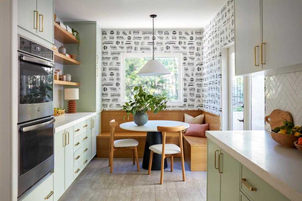 Photo of a mid-sized midcentury galley separate kitchen in Los Angeles with an undermount sink, recessed-panel cabinets, green cabinets, quartz benchtops, white splashback, ceramic splashback, stainless steel appliances, porcelain floors, no island, grey floor and white benchtop.