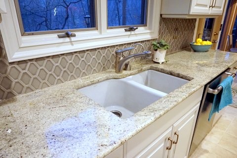 Example of a transitional kitchen design with raised-panel cabinets, beige cabinets, granite countertops and beige backsplash