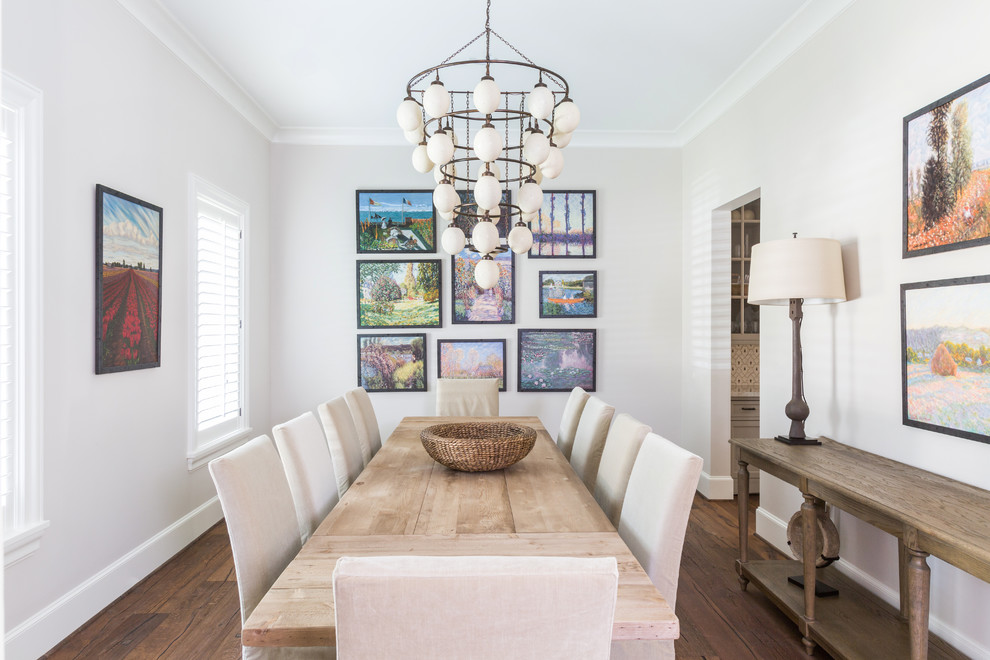 Inspiration for a traditional separate dining room in Houston with white walls and medium hardwood floors.