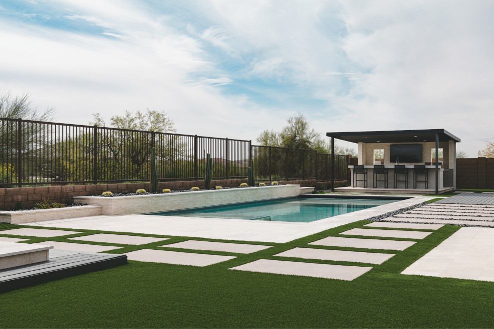 Идея дизайна: прямоугольный ландшафтный бассейн на заднем дворе в стиле модернизм с покрытием из каменной брусчатки