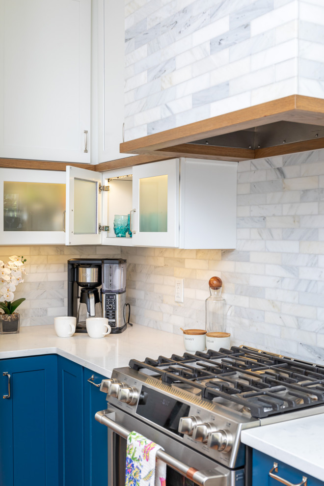 Example of a mid-sized transitional l-shaped medium tone wood floor and brown floor eat-in kitchen design in Raleigh with an undermount sink, shaker cabinets, blue cabinets, quartzite countertops, white backsplash, marble backsplash, stainless steel appliances, an island and white countertops