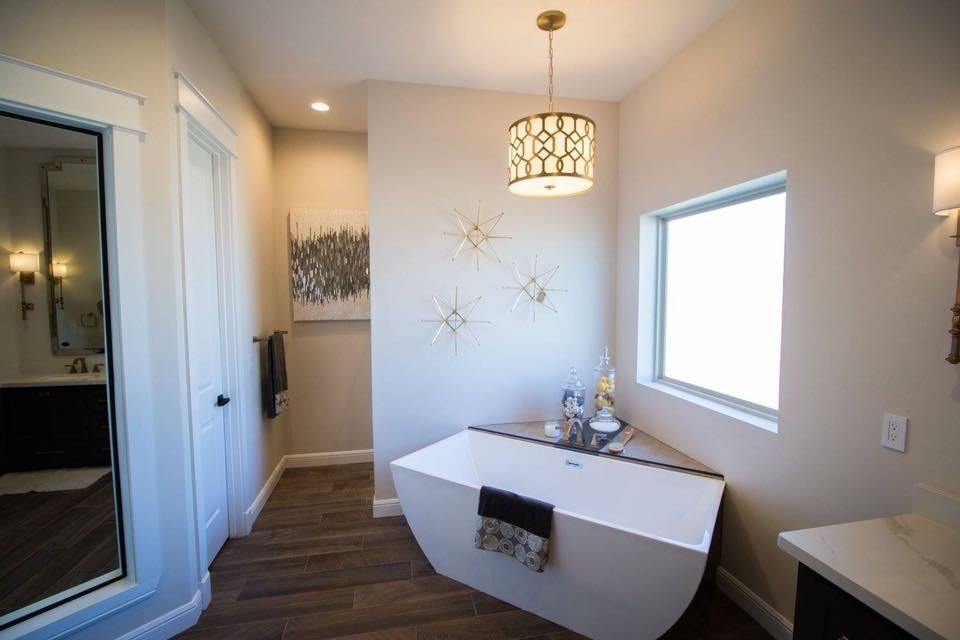 Freestanding bathtub - mid-sized transitional master beige tile and ceramic tile medium tone wood floor and brown floor freestanding bathtub idea with shaker cabinets, dark wood cabinets, a two-piece toilet, beige walls, an undermount sink, quartz countertops and a hinged shower door