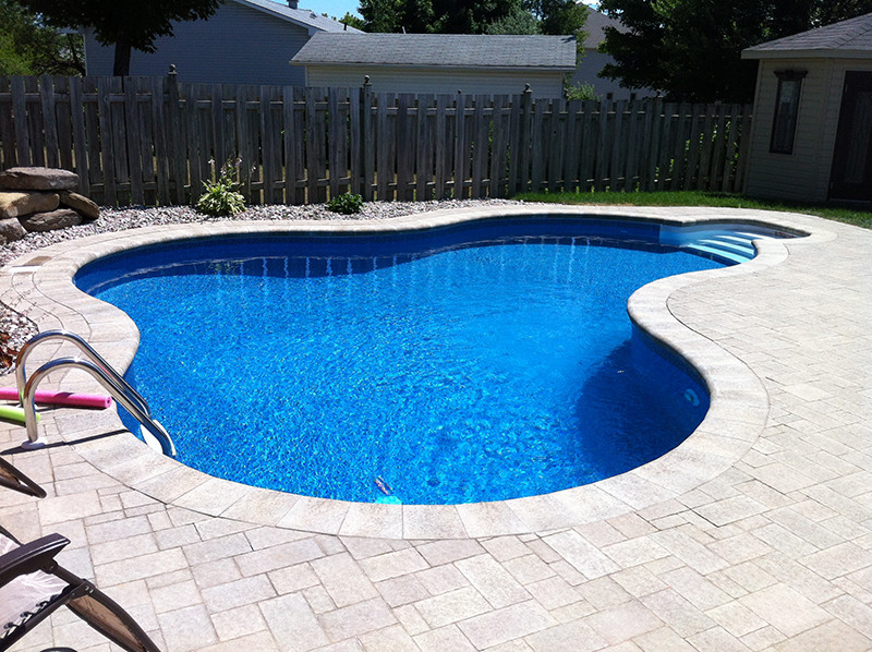 Example of a large classic backyard stone and custom-shaped natural pool design