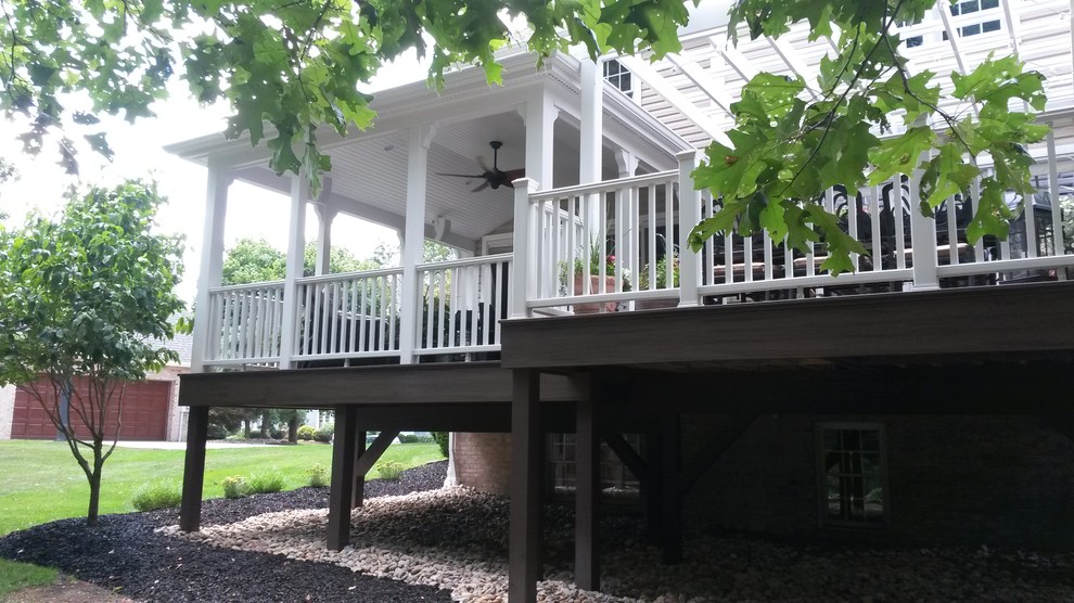 Photo of a large traditional backyard deck in Other with a roof extension.