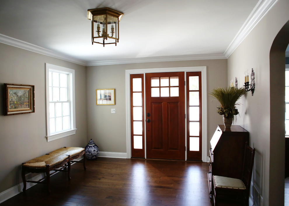 Entryway - large traditional dark wood floor and brown floor entryway idea in New York with beige walls and a dark wood front door