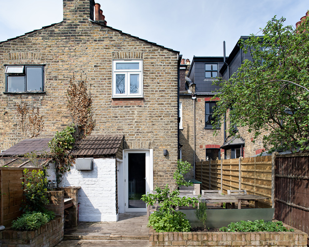 Inspiration for a mid-sized transitional two-storey brick beige house exterior in London with a gable roof and a shingle roof.