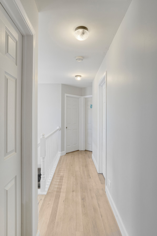 На фото: коридор среднего размера в стиле неоклассика (современная классика) с серыми стенами, полом из винила и бежевым полом с