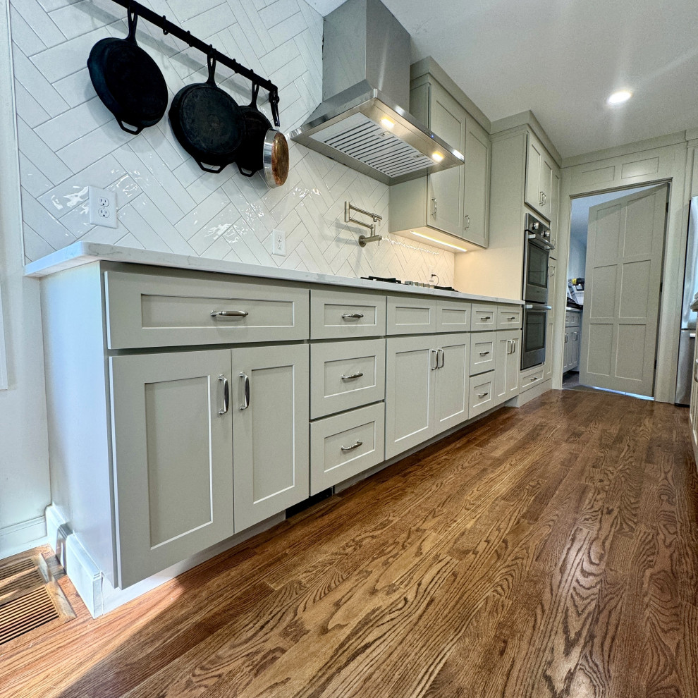 Open concept kitchen - mid-sized transitional u-shaped medium tone wood floor and brown floor open concept kitchen idea in Atlanta with an undermount sink, shaker cabinets, beige cabinets, granite countertops, white backsplash, stainless steel appliances, an island and white countertops