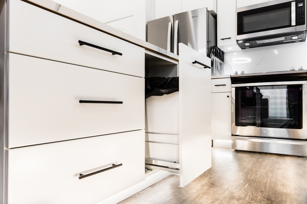 Inspiration for a small modern l-shaped open plan kitchen in Dallas with flat-panel cabinets, white cabinets, white splashback, stainless steel appliances, vinyl floors, with island, brown floor, white benchtop, an undermount sink, glass benchtops and porcelain splashback.