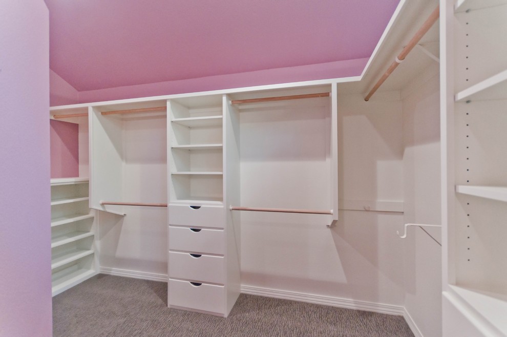 Photo of a large traditional women's walk-in wardrobe in Portland with white cabinets, flat-panel cabinets and carpet.