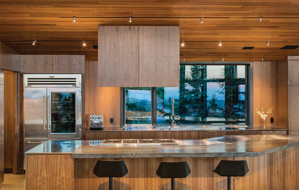 Photo of a large contemporary kitchen in Other with an integrated sink, flat-panel cabinets, medium wood cabinets, stainless steel appliances, with island, stainless steel benchtops and window splashback.