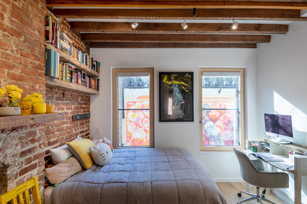 Design ideas for an industrial kids' room for girls in New York with white walls, light hardwood floors, beige floor, exposed beam and brick walls.