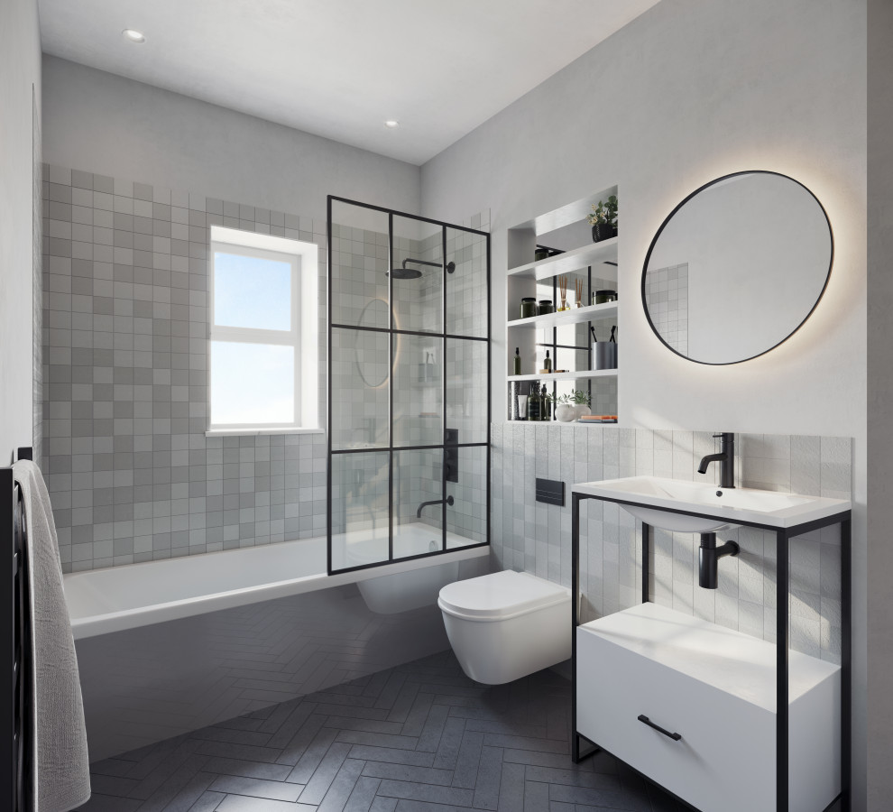 This is an example of a small modern grey and black bathroom in London with flat-panel cabinets, white cabinets, a built-in bath, a shower/bath combination, a wall mounted toilet, grey tiles, ceramic tiles, grey walls, ceramic flooring, black floors, a hinged door, a wall niche, a single sink and a freestanding vanity unit.