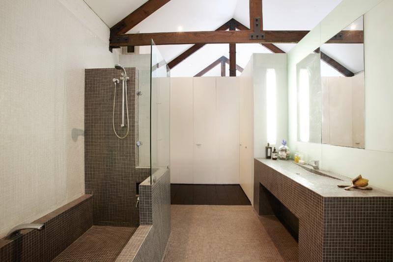 Inspiration for a large industrial 3/4 bathroom in Melbourne with flat-panel cabinets, white cabinets, a drop-in tub, an open shower, a wall-mount toilet, gray tile, mosaic tile, white walls, mosaic tile floors, a trough sink and tile benchtops.