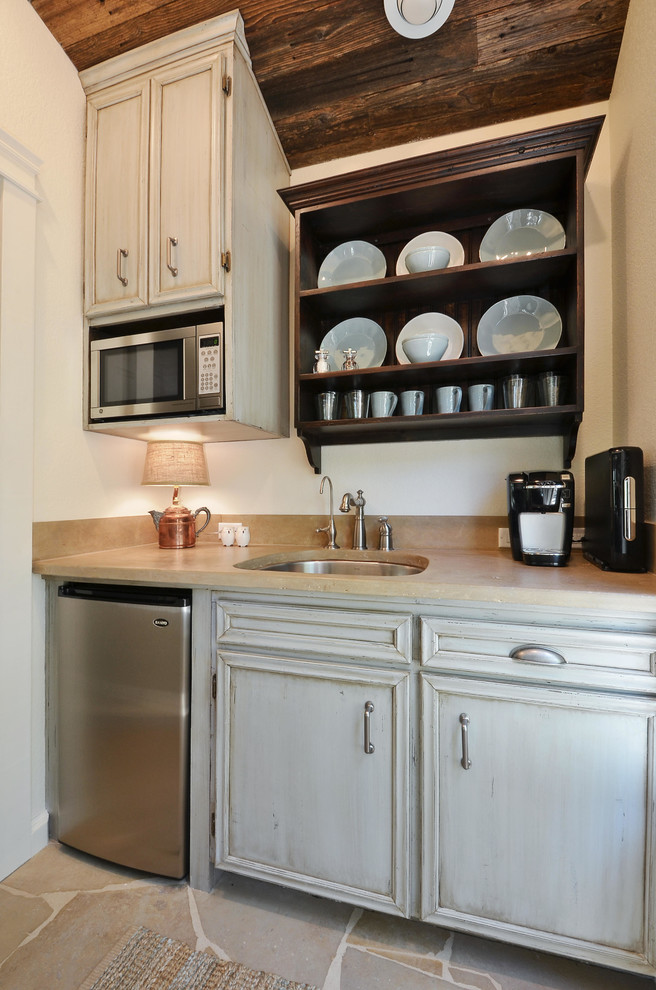 Design ideas for a small country galley separate kitchen in Austin with an undermount sink, distressed cabinets, limestone benchtops, stone slab splashback, stainless steel appliances and limestone floors.