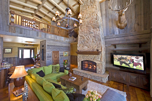 Inspiration for an expansive country formal open concept living room in Phoenix with brown walls, medium hardwood floors, a standard fireplace, a stone fireplace surround and a freestanding tv.