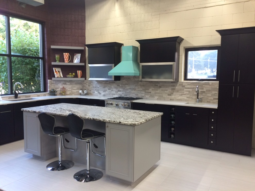 This is an example of a mid-sized modern l-shaped kitchen in Chicago with an undermount sink, flat-panel cabinets, dark wood cabinets, quartz benchtops, grey splashback, stone tile splashback, coloured appliances, porcelain floors and with island.
