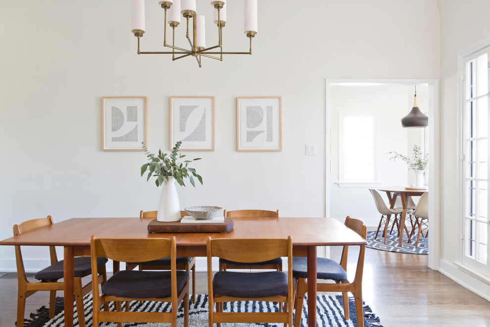 This is an example of a midcentury separate dining room in San Francisco with white walls, medium hardwood floors and brown floor.