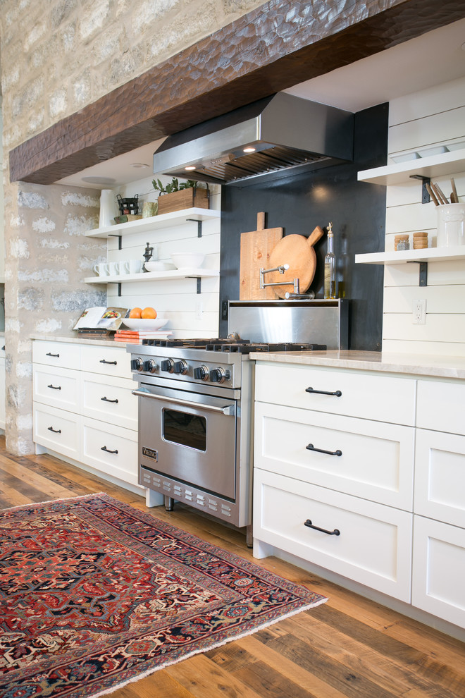 Design ideas for a country kitchen in Austin with a farmhouse sink, shaker cabinets, white cabinets, marble benchtops, white splashback, timber splashback, stainless steel appliances, medium hardwood floors and with island.