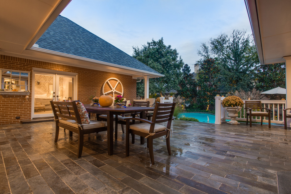 Inspiration for a traditional backyard patio in Dallas with natural stone pavers and no cover.