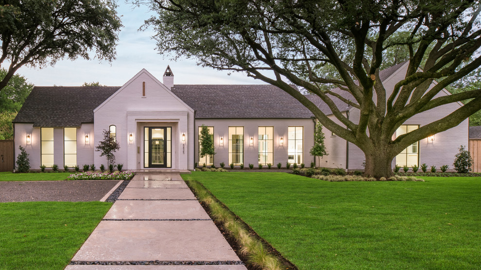Large transitional one-storey brick white house exterior in Dallas with a gable roof and a shingle roof.