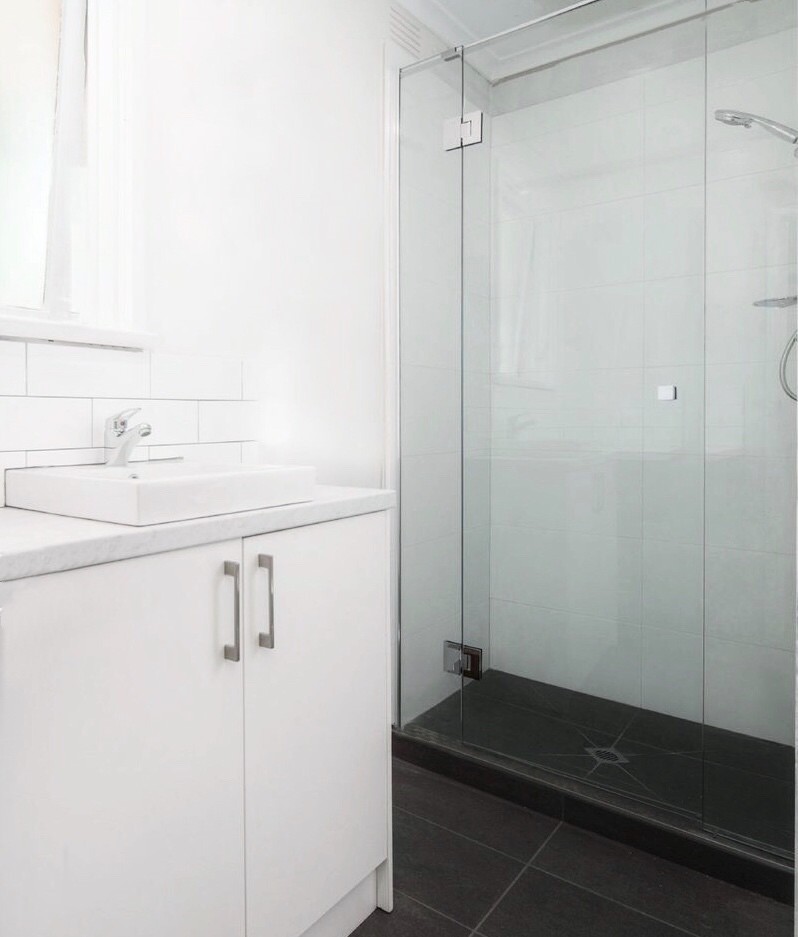 This is an example of a mid-sized contemporary master bathroom in Melbourne with white tile, ceramic tile, white walls, ceramic floors, a vessel sink, engineered quartz benchtops, a hinged shower door, white benchtops, white cabinets, an alcove shower and grey floor.