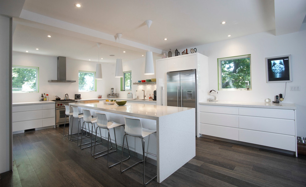 This is an example of a contemporary l-shaped eat-in kitchen in Toronto with flat-panel cabinets, white cabinets and stainless steel appliances.
