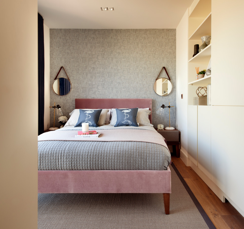 This is an example of a contemporary bedroom in London with grey walls, medium hardwood floors and brown floor.