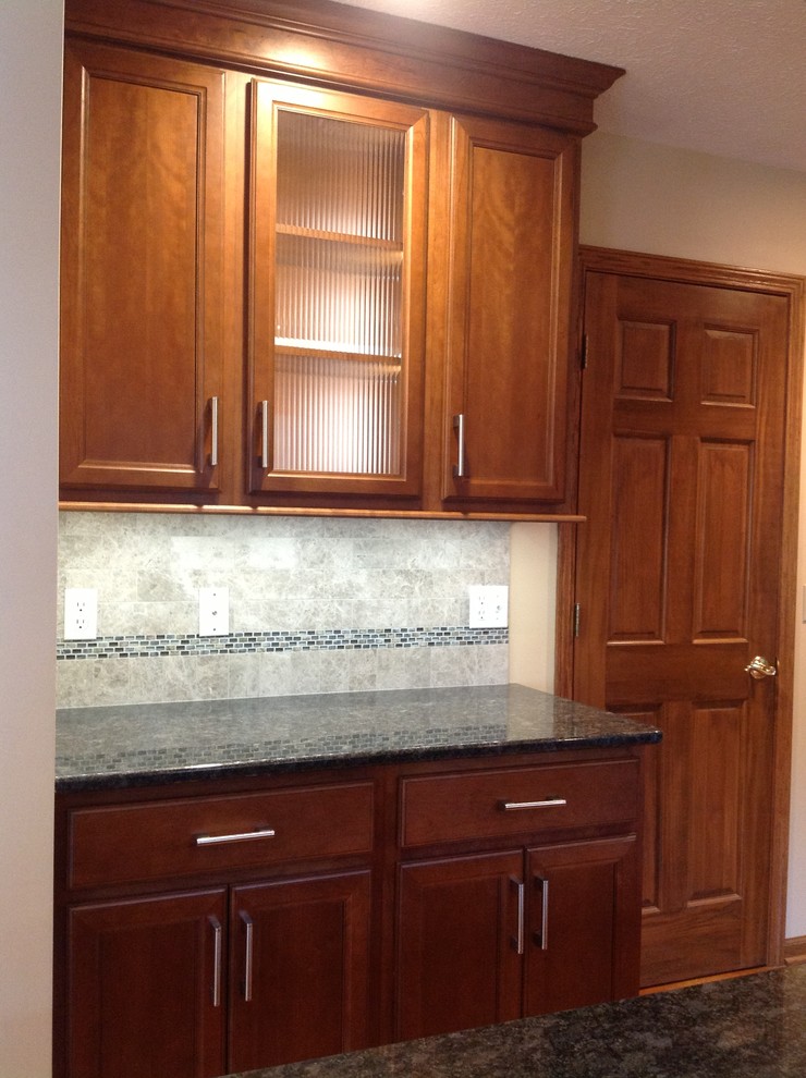 Inspiration for a mid-sized transitional l-shaped medium tone wood floor eat-in kitchen remodel with an undermount sink, recessed-panel cabinets, medium tone wood cabinets, granite countertops, gray backsplash, stone tile backsplash, stainless steel appliances, gray walls and an island